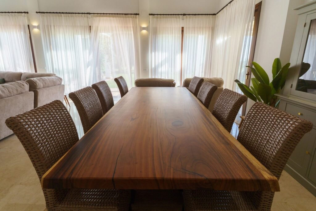 Wooden dining table with wicker chairs in modern dining room